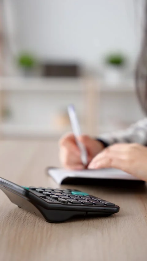 Closeup of hands using calculator Stock Footage 262383179