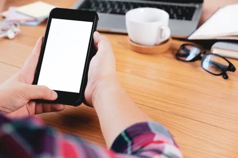 Closeup hands using smartphone mockup at the office desk. Stock Photos