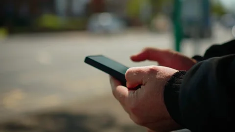 Closeup hands using smartphone on urban street background with blurred traffic Stock-Footage 333580335