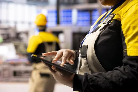 Closeup of hands using tablet in factory Stock Photos