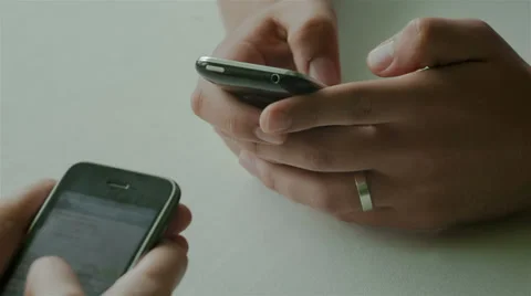 Closeup of hands using two mobile phones Stock Footage 39615393