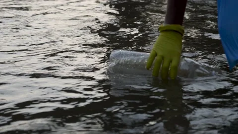Closeup hands volunteer cleaning up a river. Picking up trash water river Stock Footage 159571333