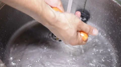 Closeup of hands washing carrot 库存影片 30257583