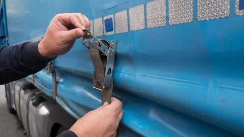 Closeup hands working cargo strap. Stock Photos