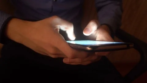 Closeup of hands of a young man flipping through the news on the smartphone Stock Footage 83624989