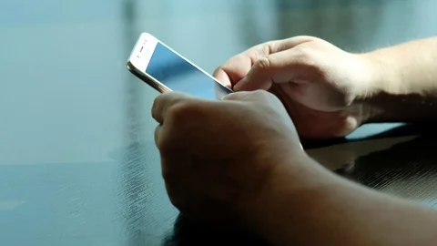 Closeup of hands of a young man flipping through the news on the smartphone. Stock Footage 111758920