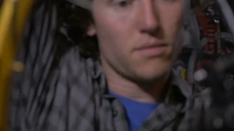 Closeup of a handsome young man working on a mountain bike Stock Footage 69908636