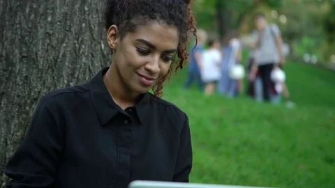 Closeup happy curly afro-american girl in black dress with makeup on working on Stock Footage