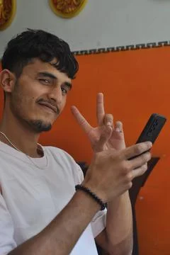 Closeup of a happy young guy looking at camera with showing peace sign Stock Photos