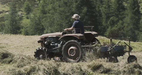 Closeup of a hay tedder working on Alpine mountain pastures in the Italian Alps Stock Footage 319150104