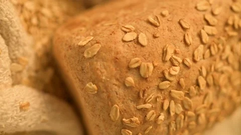 Closeup HD footage of a loaf of bread topped with cereal grain seeds on a burlap Stock Footage 162173382