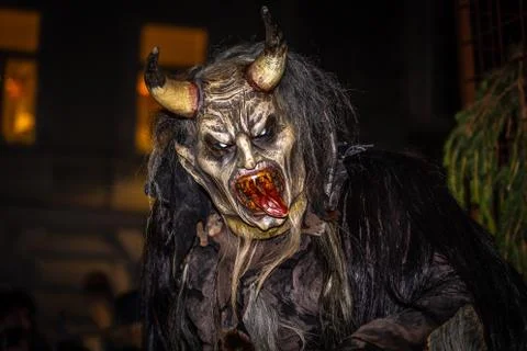 Closeup on head of grinning horned devil with red tongue Foto stock