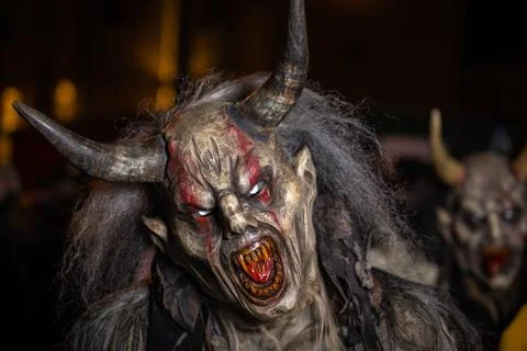 Closeup on head of grinning horned devil with red tongue Stock Photos