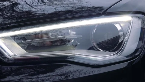 Closeup on a headlight of a dark gray car Vídeo Stock 77300505