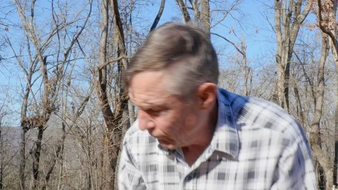 Closeup of a Healthy Older Man Unloading Tree Trunks in 4K Stock Footage 85969368