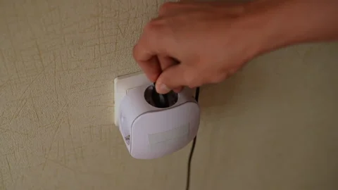 Closeup high-angle view of unrecognizable man carefully inserting plug into Stock Footage 291465079