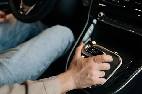 Closeup high-angle view of unrecognizable male sitting on driver seat shifting Stock Photos