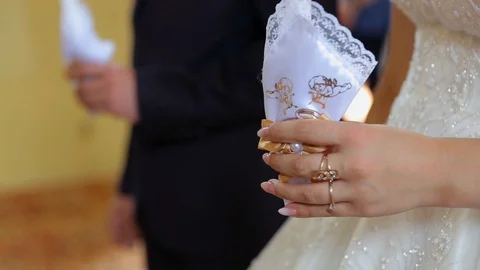 A closeup of high yellow candles held by newlyweds during the wedding ceremony Stockbeeldmateriaal 123702154