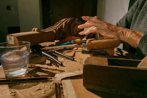 A closeup of highly skilled hands expertly shaping wood, showcasing the intri Stock Photos