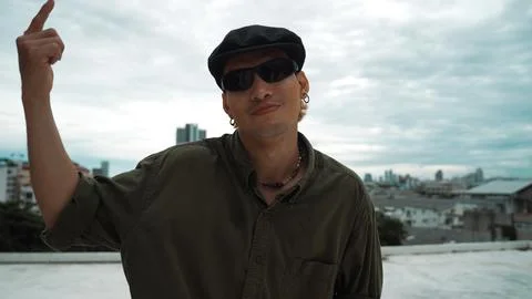 Closeup of hipster put hands up at rooftop while looking at camera. Endeavor. 스톡 사진