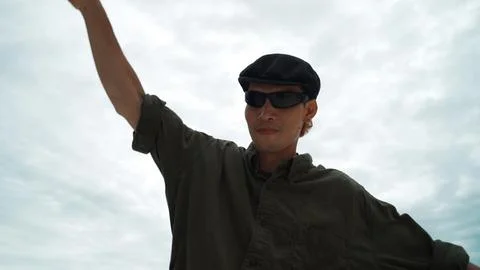 Closeup of hipster put hands up at rooftop while looking at camera. Endeavor. 写真素材