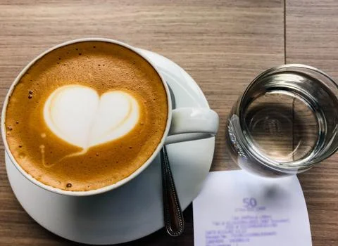 Closeup hot cappuccino on table with spoon Stock Photos
