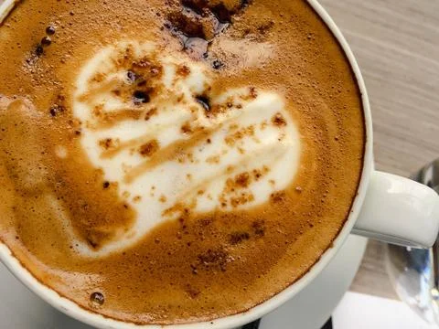 Closeup hot cappuccino on table with spoon Stock Photos