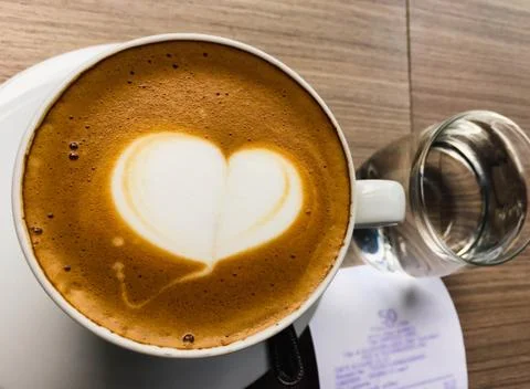 Closeup hot cappuccino on table with spoon Stock Photos
