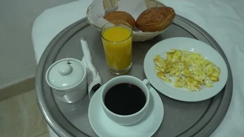 Closeup of a hotel breakfast of scrambled eggs, coffee, soda and breads in the m Stock Footage 196737323