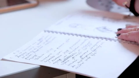 Closeup of how Students talk and make notes on a notebook with a pen and make Stock Footage 136666925