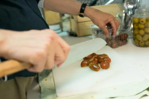 Closeup of human hand cutting cherry tomatoes Stock Photos