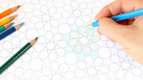 Closeup of human hand drawing, coloring decorative arab tile pattern with Video stock 105163704