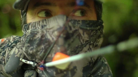 Closeup of hunter as he takes aim and releases arrow in the forest. Vídeo Stock 50029601