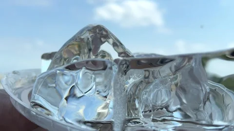 Closeup of ice cubes rotating on nature background Video stock 295302297