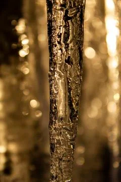 Closeup of icicle with air bubbles inside, bokeh. Stock Photos