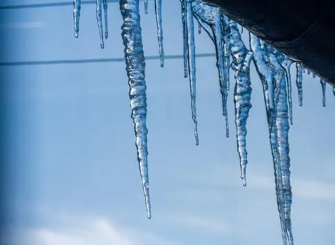 Closeup icicles background. Icicles hanging down from a roof. Cold weather, w Stock-Fotos