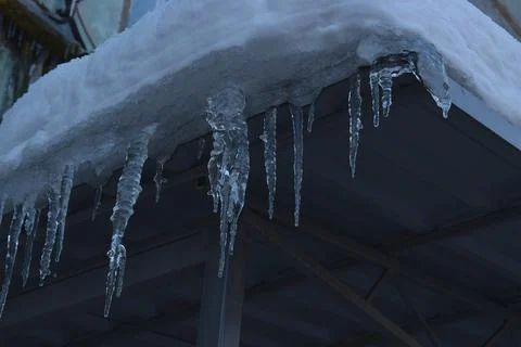 Closeup icicles background. Icicles hanging down from a roof. Stock Photos