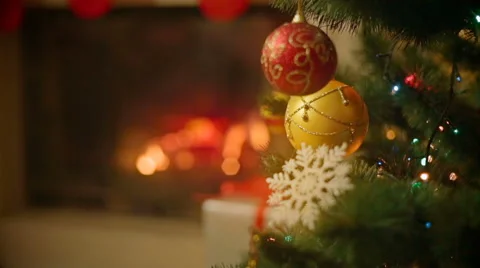 Closeup image of beautiful decorated Christmas tree in front of burning firep Stock Footage