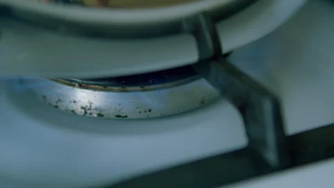 A closeup image depicting the flame and burner of a gas stove in detail and text Stock Footage 306718892