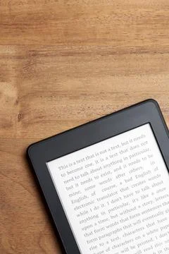 Closeup image of an electronic reader with text on the screen on a wooden desk Foto stock