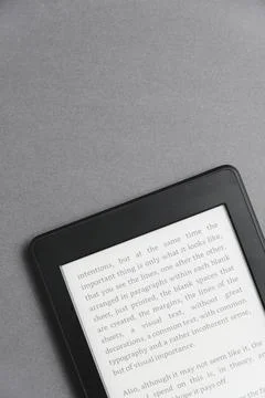 Closeup image of an electronic reader with text on the screen on a grey surface Stock Photos