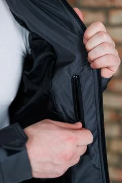 A closeup image features a hand gracefully reaching for a jacket pocket, wh.. Foto stock