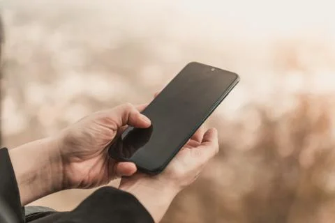 Closeup image of female hands using smartphone in mountain day, search or soc Foto stock