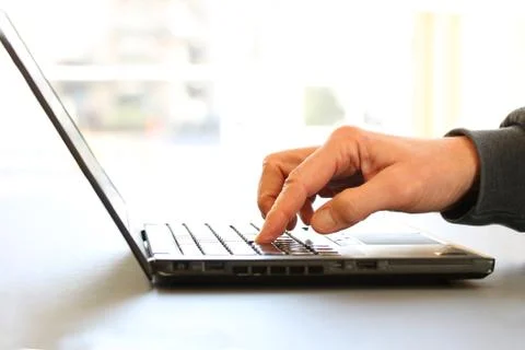 Closeup image of a finger touching texting on keyboard on a laptop computer. Stock Photos