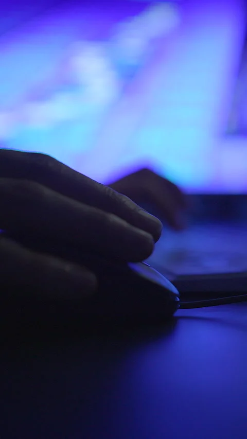 A closeup image of a hand operating a computer mouse during the nighttime Stock Footage 295436285