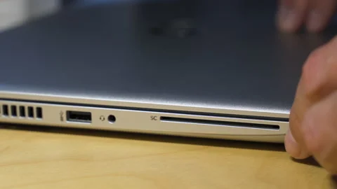 Closeup image of a man opening a laptop computer on a table Stock Footage 153111696