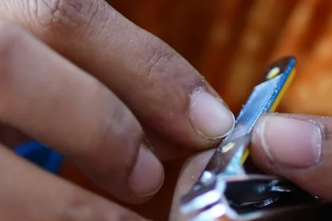 Closeup image of manicuring nails and smoothing edges with stainless steel fi Stock Photos