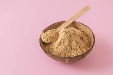 Closeup image of raw maca root powder on pink background Photos