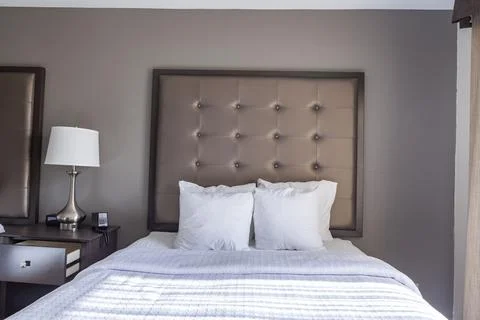 Closeup image of a ready made queen size bed with white bedding and a bunch o Stock-Fotos