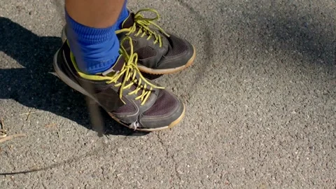 A Closeup Image of Running Shoes Situated on an Asphalt Surface Stock Footage 318924057